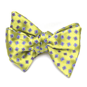 A yellow bow tie with purple squares on it.