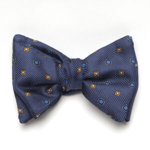 A blue bow tie with brown and yellow flowers.