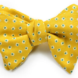 A yellow bow tie with white and green flowers.